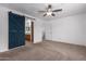 Spacious main bedroom with carpet, ceiling fan, and sliding barn door to en-suite at 22672 W Solano Dr, Buckeye, AZ 85326