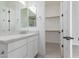 Modern bathroom with stone countertops, white cabinets, and an adjacent walk-in closet at 24372 N 96Th Ln, Peoria, AZ 85383