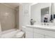 Cozy bathroom features a neutral tiled shower, white cabinets, and modern fixtures at 24372 N 96Th Ln, Peoria, AZ 85383