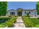 Inviting front entrance with stone walkway and lush landscaping leading to a charming white stucco home at 24372 N 96Th Ln, Peoria, AZ 85383