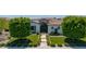 Charming home featuring lush green lawns, decorative shrubbery, and a welcoming walkway to the front door at 24372 N 96Th Ln, Peoria, AZ 85383