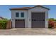 Attached two-car garage with a paved driveway, complemented by neat landscaping at 24372 N 96Th Ln, Peoria, AZ 85383