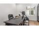 A home office space features a dark wood desk and chair with natural light from the window and backyard view at 24372 N 96Th Ln, Peoria, AZ 85383