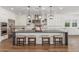 Well-appointed kitchen featuring white cabinetry, stainless steel appliances, and a large island with seating at 24372 N 96Th Ln, Peoria, AZ 85383