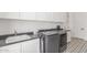 Laundry room features modern washer and dryer, ample cabinet space for storage, and sleek black countertops at 24372 N 96Th Ln, Peoria, AZ 85383