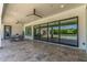 Covered patio area with stone flooring, ceiling fans, and expansive sliding glass doors overlooking pool at 24372 N 96Th Ln, Peoria, AZ 85383