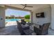 Covered patio featuring comfortable seating and a view of the backyard with a basketball court and pool at 24372 N 96Th Ln, Peoria, AZ 85383