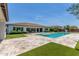 Backyard featuring a pristine pool and spa, surrounded by travertine tile and manicured landscaping at 24372 N 96Th Ln, Peoria, AZ 85383