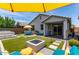 Inviting backyard featuring artificial turf, hot tub, a fire pit and stylish outdoor seating for relaxation and entertainment at 25289 N 143Rd Dr, Surprise, AZ 85387