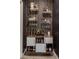 A stylish home bar with a collection of spirits, glassware, and a decorative geometric patterned wall at 25289 N 143Rd Dr, Surprise, AZ 85387