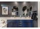 Bathroom featuring double sinks, white countertops, navy cabinets and unique wall art at 25289 N 143Rd Dr, Surprise, AZ 85387