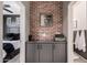 Charming hallway with a brick accent wall, built-in storage, and access to the bedroom and bathroom at 25289 N 143Rd Dr, Surprise, AZ 85387