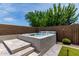 Inviting backyard featuring a built-in hot tub with surrounding landscaping and a privacy wall at 25289 N 143Rd Dr, Surprise, AZ 85387