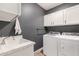 Efficient laundry room with modern washer and dryer, sink, and ample cabinet space at 25289 N 143Rd Dr, Surprise, AZ 85387