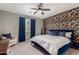 Serene bedroom featuring a blue upholstered bed, contemporary decor, and a patterned accent wall at 25289 N 143Rd Dr, Surprise, AZ 85387