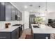 Modern kitchen featuring an island with counter seating, stainless steel appliances, and designer pendant lighting at 3053 W Straight Arrow Ln, Phoenix, AZ 85083