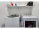 Convenient laundry room featuring a full-sized washer and dryer with storage space on shelves above at 3053 W Straight Arrow Ln, Phoenix, AZ 85083