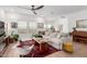 Bright living room boasts a modern ceiling fan, large windows, cozy furniture and contemporary decor at 3053 W Straight Arrow Ln, Phoenix, AZ 85083