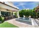 Wide backyard view with covered patio, outdoor dining, grill, pool with fountain, and green landscaping at 3511 N 39Th Pl, Phoenix, AZ 85018