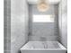 Bright bathtub with a tile surround, modern fixtures, and plenty of natural light at 3511 N 39Th Pl, Phoenix, AZ 85018
