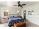 Inviting bedroom featuring a dark ceiling fan, neutral walls, and a cozy bed with a comfy leather bench at 3511 N 39Th Pl, Phoenix, AZ 85018