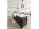 Kitchen with white cabinets, marble countertops, a dark island with a farmhouse sink, and pendant lighting at 3511 N 39Th Pl, Phoenix, AZ 85018
