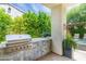 Outdoor kitchen featuring a grill, tiled countertop, and lush landscaping with a view of pool at 3511 N 39Th Pl, Phoenix, AZ 85018