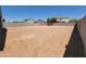 Large backyard with dirt and surrounded by a block wall offering privacy and space for customization at 37172 W Parador Ln, Maricopa, AZ 85138