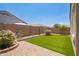 Backyard featuring desert landscaping, synthetic grass, and a paved patio at 41005 W Crane Dr, Maricopa, AZ 85138