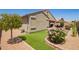 Backyard with desert landscaping, synthetic grass, flowering bushes, and a patio at 41005 W Crane Dr, Maricopa, AZ 85138