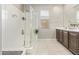 Bathroom with a glass enclosed shower, white tile, and a double sink vanity at 41005 W Crane Dr, Maricopa, AZ 85138