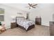 This bedroom features neutral walls, carpet, ceiling fan, and coordinated furniture at 41005 W Crane Dr, Maricopa, AZ 85138