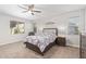 This bedroom features neutral walls, carpet, ceiling fan, and coordinated furniture at 41005 W Crane Dr, Maricopa, AZ 85138