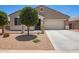 Charming single-story home featuring desert landscaping, a two-car garage, and a welcoming front porch at 41005 W Crane Dr, Maricopa, AZ 85138