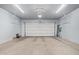 Spacious, empty two-car garage with overhead lighting and a sealed concrete floor at 41005 W Crane Dr, Maricopa, AZ 85138