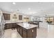 Open concept kitchen featuring a central island, stainless steel appliances, and seamless transition to dining and living areas at 41005 W Crane Dr, Maricopa, AZ 85138