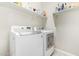Bright laundry room featuring a side-by-side washer and dryer with white cabinets at 41005 W Crane Dr, Maricopa, AZ 85138