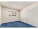 Simple bedroom featuring neutral walls, blue carpet, and a window at 4402 W El Caminito Dr, Glendale, AZ 85302