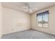 This bedroom features a light gray carpet, ceiling fan and window at 4402 W El Caminito Dr, Glendale, AZ 85302