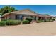 Brick home featuring a well-manicured gravel yard and lush landscaping at 4402 W El Caminito Dr, Glendale, AZ 85302