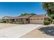 Charming brick home featuring a long driveway, two-car garage and mature landscaping at 4402 W El Caminito Dr, Glendale, AZ 85302