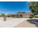 Expansive ranch-style home featuring a long driveway, two-car garage and mature landscaping at 4402 W El Caminito Dr, Glendale, AZ 85302