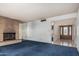 Spacious living room features a brick fireplace, plush blue carpet, and a bright entry way at 4402 W El Caminito Dr, Glendale, AZ 85302