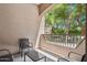 A covered balcony with views of trees and neighboring buildings has comfortable seating at 5450 E Deer Valley Dr # 1214, Phoenix, AZ 85054