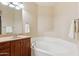 Bathroom features a soaking tub with wood cabinets and chrome fixtures at 5450 E Deer Valley Dr # 1214, Phoenix, AZ 85054
