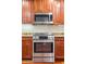 This kitchen features stainless steel appliances including oven and microwave, plus wooden cabinetry at 5450 E Deer Valley Dr # 1214, Phoenix, AZ 85054