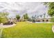 Large backyard showcasing a pool with a waterfall, patio dining area, fire pit, and lush green lawn at 550 W Powell Way, Chandler, AZ 85248