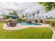 Spacious backyard with a pristine pool, rock waterfall, patio dining area, and lush green lawn at 550 W Powell Way, Chandler, AZ 85248