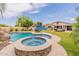 Expansive backyard featuring a sparkling pool, spa, and covered patio with ample seating and dining areas at 550 W Powell Way, Chandler, AZ 85248