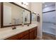 Bathroom with double sinks, wood cabinets and large mirror, leading to the shower and toilet area at 550 W Powell Way, Chandler, AZ 85248